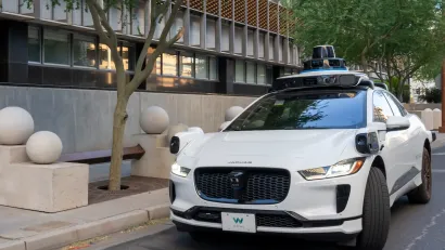 White self-driving Waymo vehicle on street in Phoenix, Arizona.
